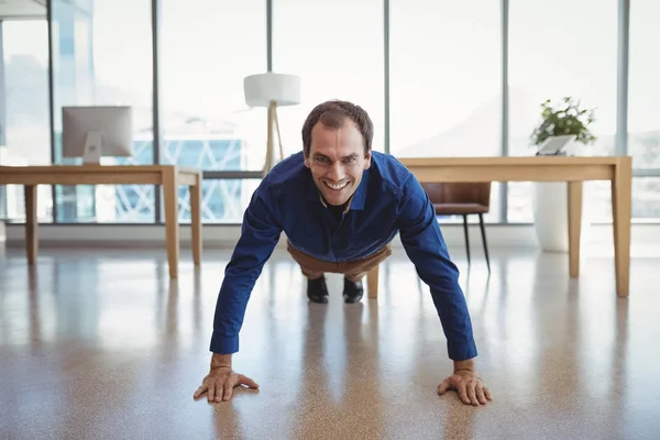 Sonriente ejecutivo haciendo flexiones — Foto de Stock