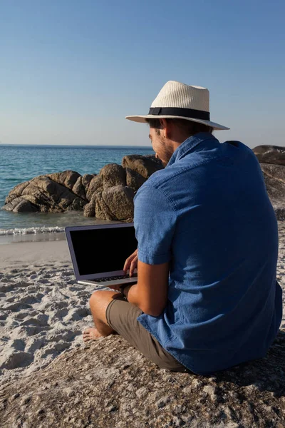 Mann auf Felsen und mit Laptop — Stockfoto