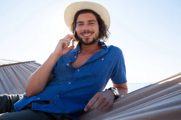 Man talking on phone while relaxing — Stock Photo, Image