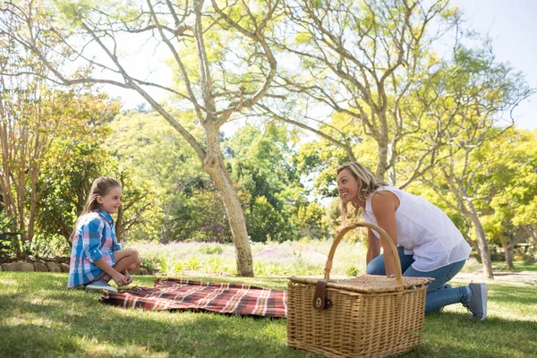 Moeder en dochter verspreiden de Picknickkleed. — Stockfoto