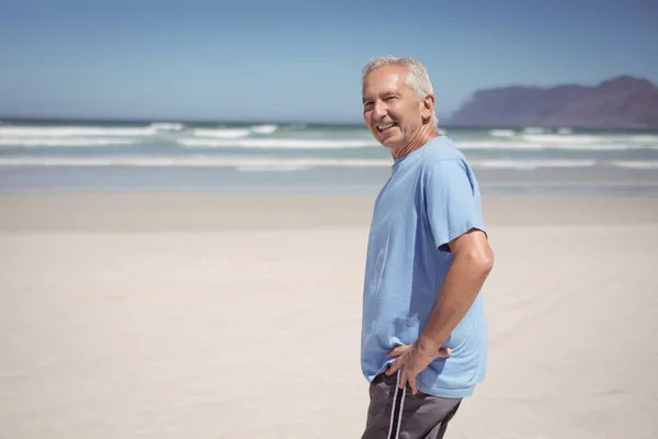 Пожилой человек стоит на пляже — стоковое фото