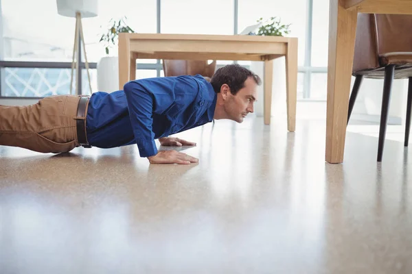 Entschlossene Führungskraft macht Liegestütze — Stockfoto