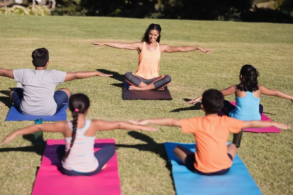 Trainer teaching stretching exercise to children — Stock Photo, Image