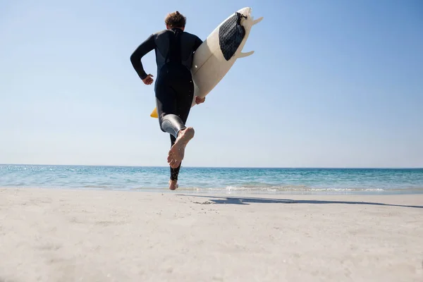 Surfer met surfboard lopend naar de zee — Stockfoto