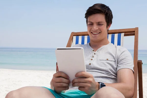 Ember ül sunlounger és a tablet használata — Stock Fotó