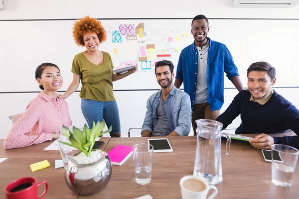 Business people at desk against whiteboard — Stock Photo, Image