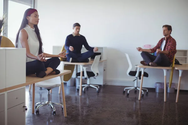 Mensen uit het bedrijfsleven het beoefenen van yoga op kantoor — Stockfoto