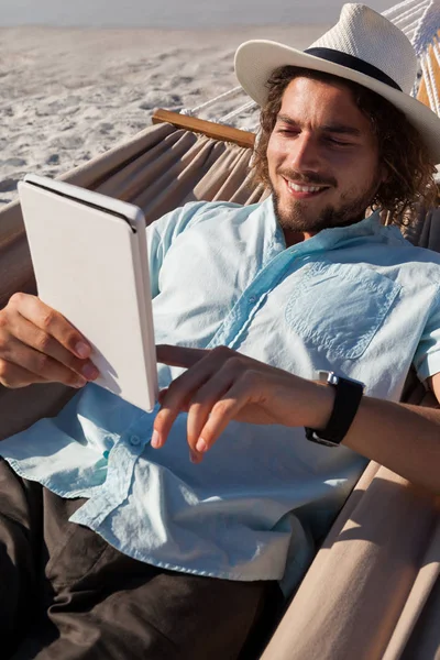 Homem relaxante na rede e usando tablet — Fotografia de Stock