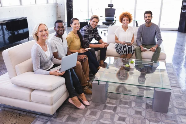 Leende kollegor sitter på soffa — Stockfoto