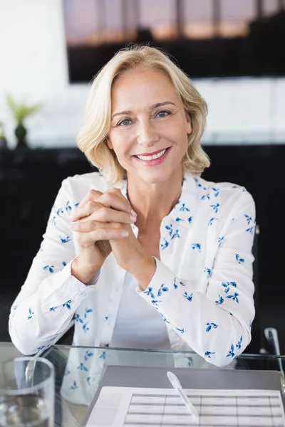 Mujer de negocios sonriente sentada en el escritorio — Foto de Stock