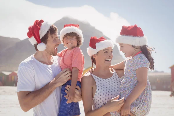 Bambini con genitori che indossano cappelli Babbo Natale — Foto Stock