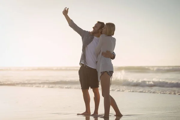 Paret tar selfie på stranden vid stranden — Stockfoto