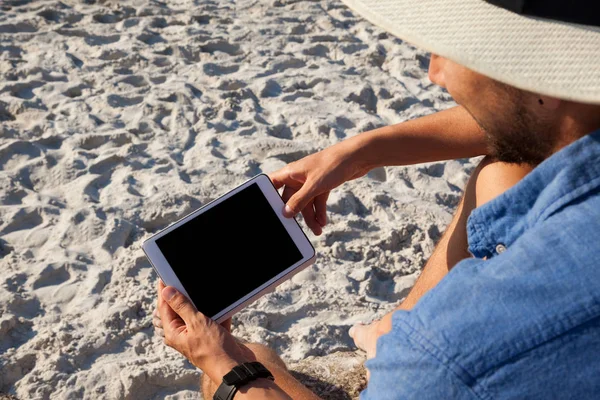 Homme utilisant une tablette numérique sur la plage — Photo