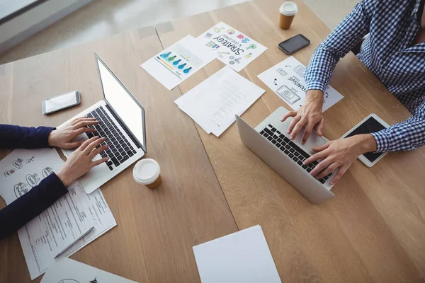 Leidinggevenden met behulp van laptop aan balie — Stockfoto