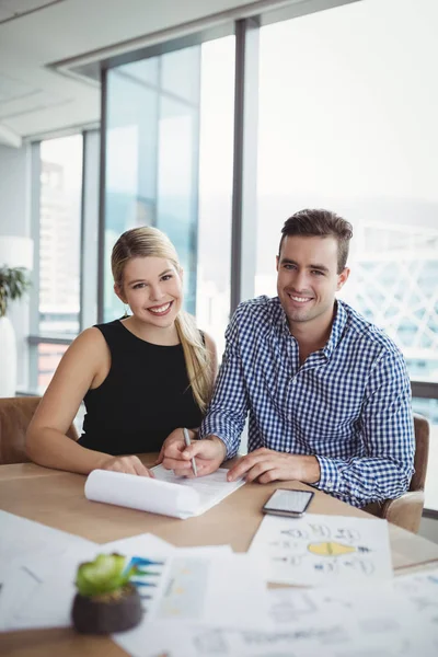 Ejecutivos discutiendo sobre papel en el escritorio — Foto de Stock