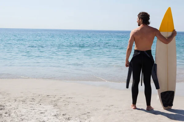 Surfista con tabla de surf mirando al mar — Foto de Stock