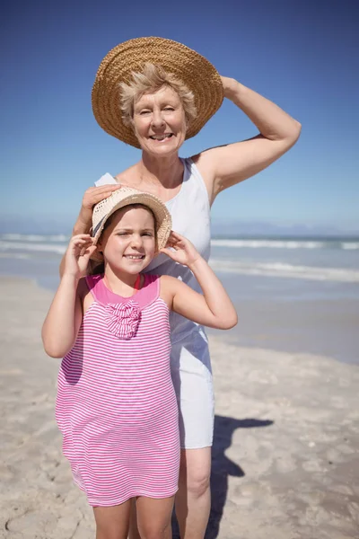Girl with grandmother wearing sun hat — Stock Photo, Image