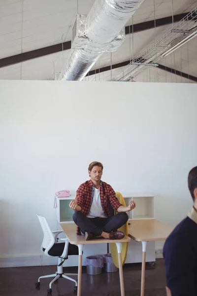 Jeune homme d'affaires faisant du yoga au bureau — Photo