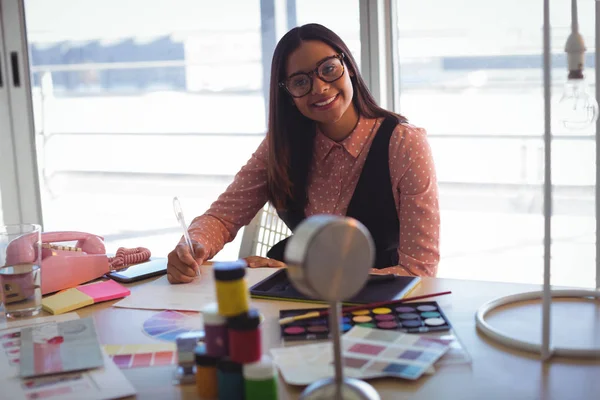 Empresária escrevendo no papel no escritório — Fotografia de Stock