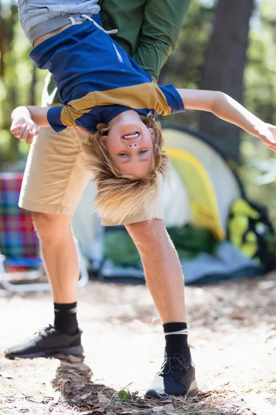 Brincalhão pai segurando filho de cabeça para baixo — Fotografia de Stock