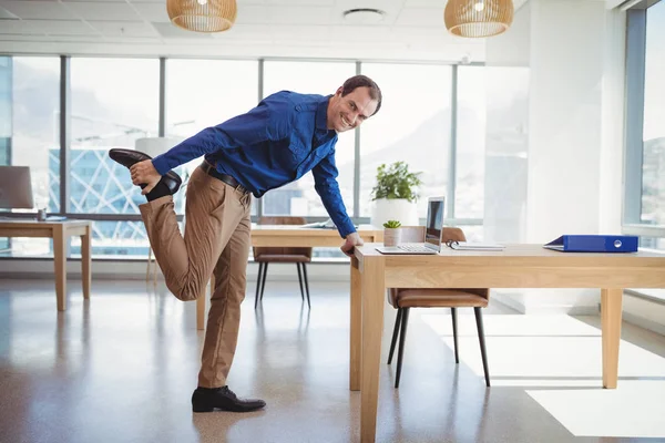 Smiling executive exercising in office — Stock Photo, Image