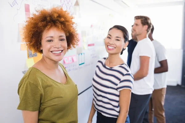 Mensen uit het bedrijfsleven permanent door whiteboard — Stockfoto