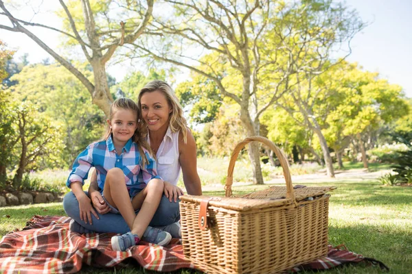Daughter on mothers lap while having picnic — Stock Photo, Image