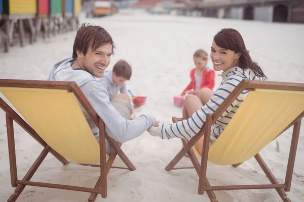 Parents se relaxant sur des chaises longues avec enfants — Photo