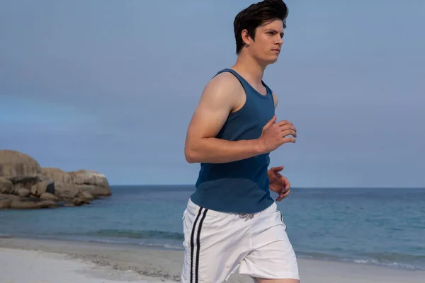 Man jogging on beach on a sunny day — Stock Photo, Image