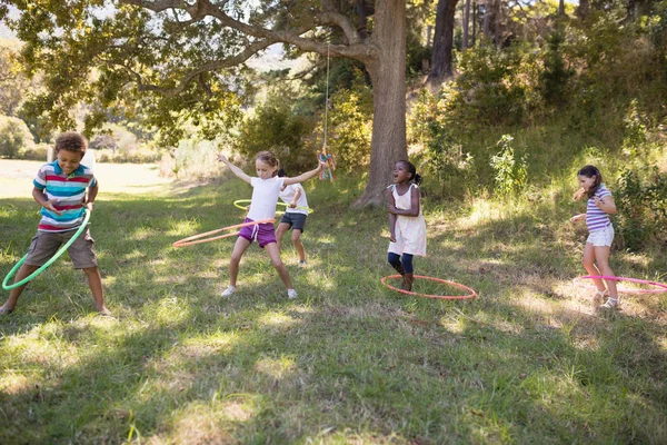 Vänner spelar med hula hoops på campingen — Stockfoto