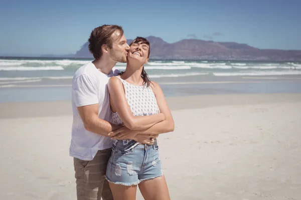 Мужчина целует женщину на пляже — стоковое фото