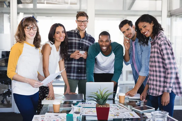 Equipo empresarial creativo de pie alrededor de la mesa — Foto de Stock