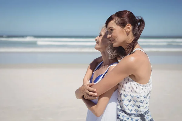 Mulher abraçando sua mãe na praia — Fotografia de Stock
