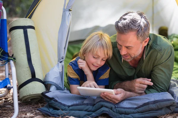 Père et fils utilisant une tablette au camping — Photo