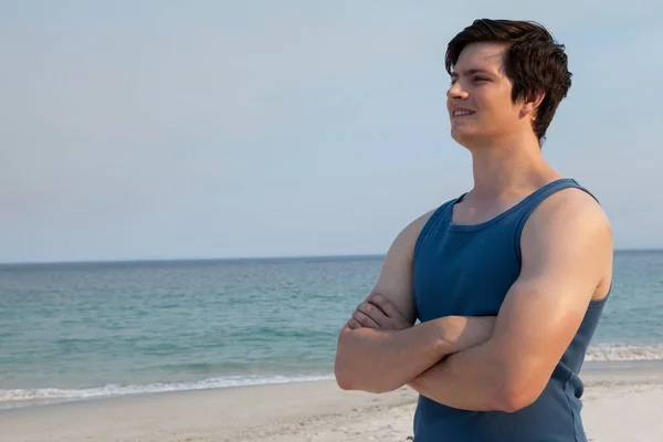 Man står på stranden med armarna korsade — Stockfoto