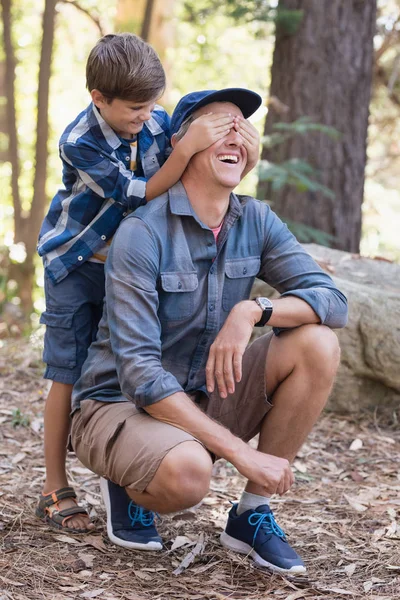Pojke som täcker fäder ögon medan vandring — Stockfoto