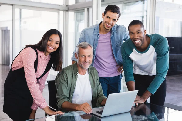 Affärsmannen och leende kollegor vid skrivbord — Stockfoto