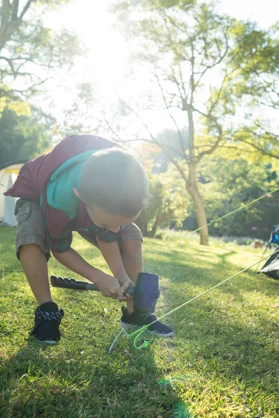 Ragazzo che monta la tenda al campeggio — Foto Stock