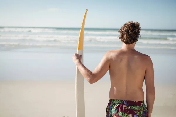 光着膀子男人在海滩的抱着冲浪板 — 图库照片