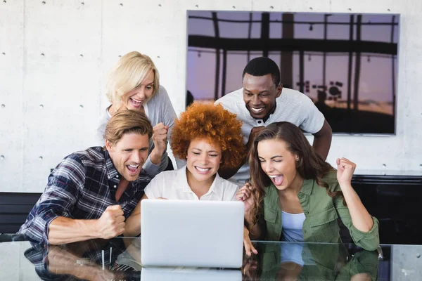 Gente alegre de negocios mirando a la computadora portátil — Foto de Stock