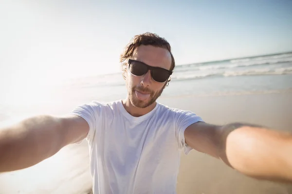 Fiatal férfi napszemüveg viselése strandon — Stock Fotó
