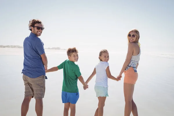 Family holding hands on shore — Stock Photo, Image