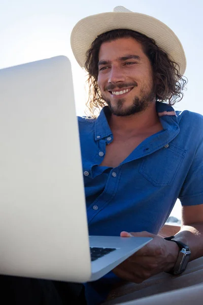 Człowiek za pomocą laptopa, relaksując się na hamaku — Zdjęcie stockowe