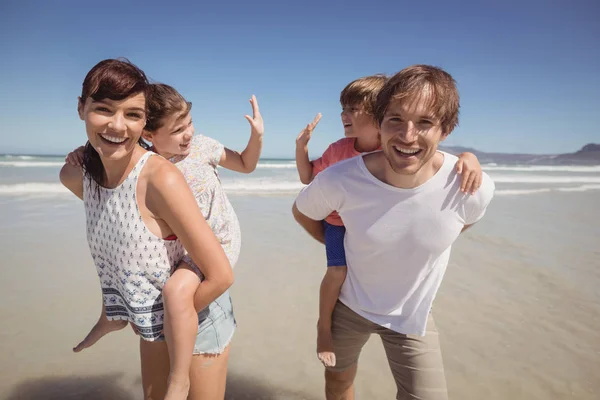 Pais piggybacking seus filhos — Fotografia de Stock