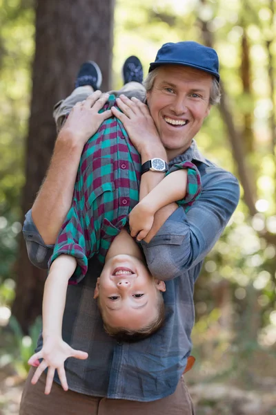 Vater trägt Sohn beim Wandern im Wald — Stockfoto