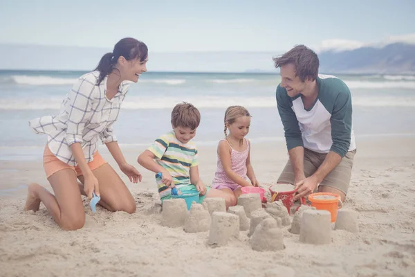 Família fazendo castelo de areia — Fotografia de Stock