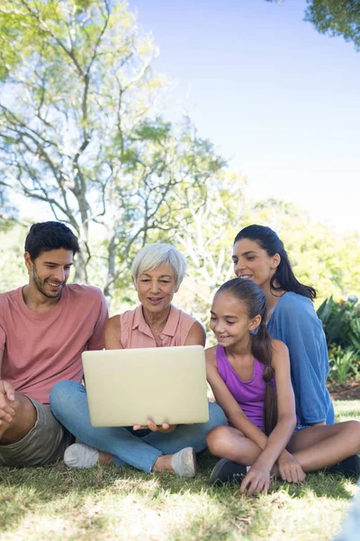 Famiglia utilizzando il computer portatile nel parco — Foto Stock