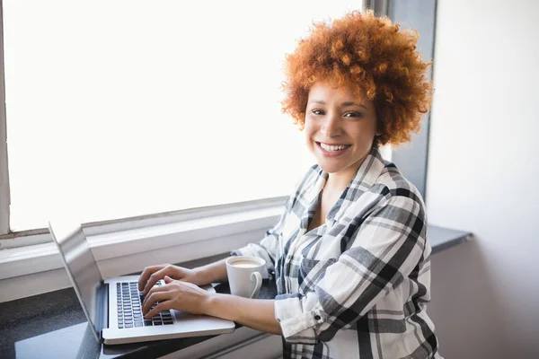 Mujer de negocios utilizando el ordenador portátil en alféizar ventana —  Fotos de Stock