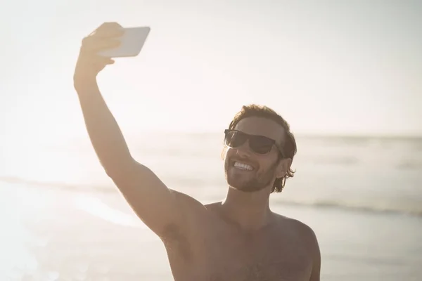 Без сорочки чоловік бере селфі на пляжі — стокове фото