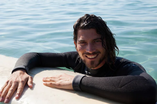 Surfer κλίνει σε σανίδα του σερφ στην θάλασσα — Φωτογραφία Αρχείου